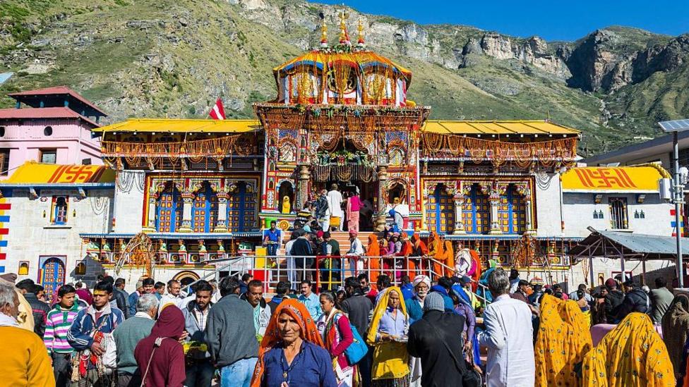 Many pilgrims are gathering in front of the colorful Badrinath Temple, one of the Char Dham destinations.