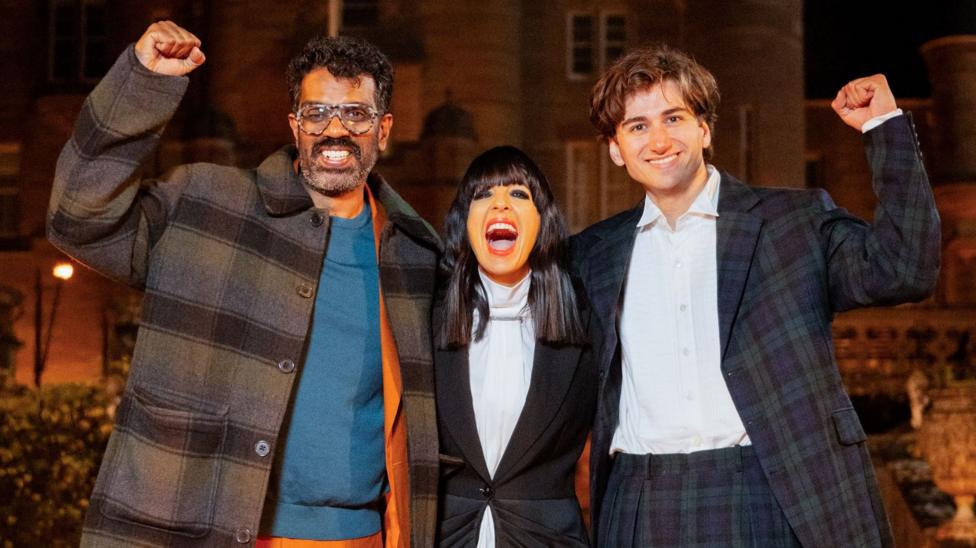Romesh Ranganathan, Claudia Winkleman and Sebastian Croft with their arms around each other and celebrating