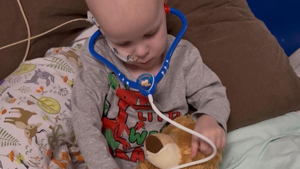 Teddy playing doctors with his toys in the hospital.